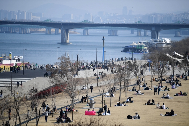 사회적 거리두기가 2단계로 완화된 이후 첫 휴일을 맞은 21일 서울 여의도 한강공원에서 시민들이 포근한 날씨를 즐기며 휴일을 만끽하고 있다.
