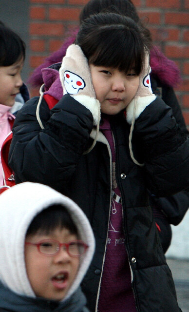 아침 최저기온이 영하로 떨어지는 반짝추위가 닥쳐 서울 마포구 아현동 소의초등학교 학생들이 손장갑으로 귀마개를 대신하거나 모자를 쓴 채 등교하고 있다. 신소영 기자 viator@hani.co.kr