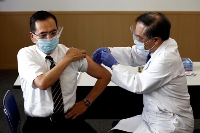 일본 국내 신종 코로나바이러스 감염증(코로나19) 백신 접종 1호인 아라키 가즈히로(왼쪽) 도쿄의료센터 원장이 지난 17일 화이자 백신을 맞고 있다. 도쿄=로이터 연합뉴스