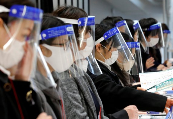 도쿄의 한 안내 데스크에서 상담원들이 마스크에 안면 보호대를 쓰고 업무를 보고 있다. 로이터 뉴스1