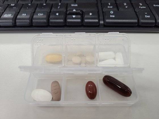 김 씨가 점심 때 먹기위해 회사에 챙겨오는 약통. 루테인·종합비타민·크릴오일·맥주효모·비타민C·콜레스테롤약·밀크씨슬이 들어있다.