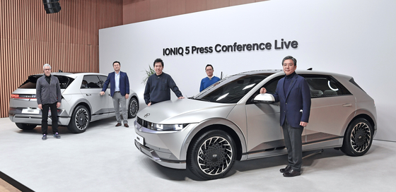 Chang Jae-hoon, CEO and President of Hyundai Motor, far right, and Lee Sang-yup, senior vice president and head of design, third from right, pose with the Ioniq 5 at an online press conference held Tuesday. [HYUNDAI MOTOR]