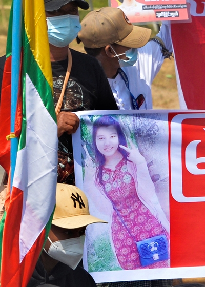 지난 17일 미얀마 시위대가 먀 뚜웨 뚜웨 카인의 사진이 담긴 현수막을 들고 있다. 머리에 총상을 입은 카인은 당시 치료 중이었다. AFP 연합뉴스