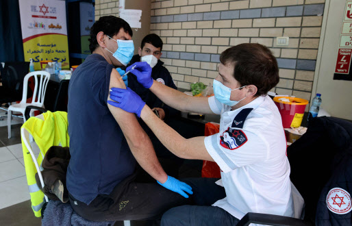 이스라엘의 매겐 데이비드 아돔 의료서비스의 한 구급대원이 백신을 주사하고 있다.(사진=AFP)