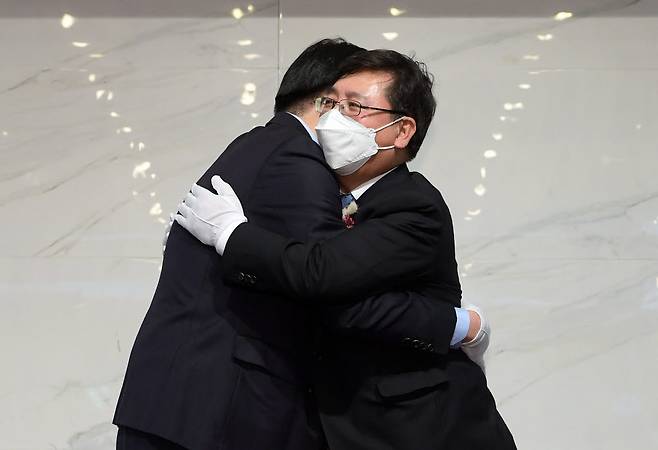 이홍구 전임 회장과 조준희 신임 회장이 포옹하고 있다.