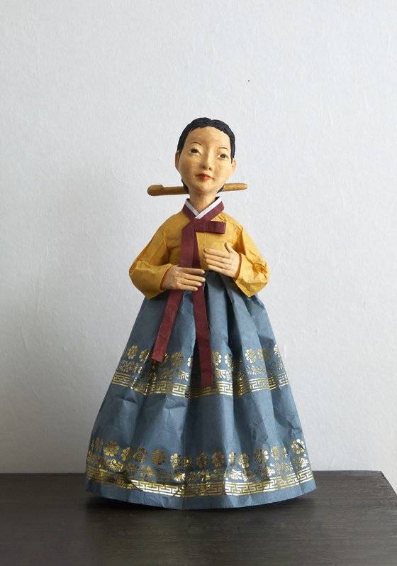 닥종이 인형을 만들 때 인상이 강해지는 걸 막기 위해 눈동자를 안 넣는 편인데 이 작품은 작가의 엄마를 표현한 작품이라 특별히 눈동자를 나타냈다.