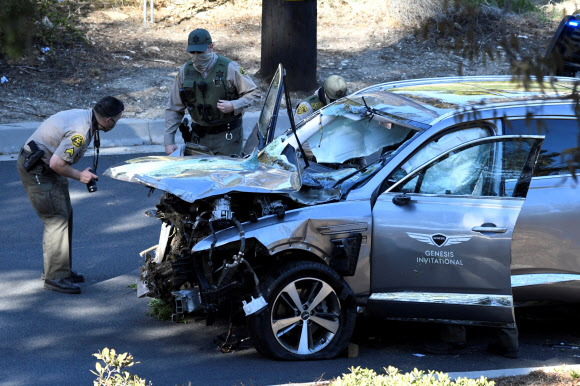 LA 카운티 보안관들이 23일(현지시간) 미국 캘리포니아주 로스앤젤레스에서 발생한 ‘골프 황제’ 타이거 우즈의 자동차 전복 사고 현장에 출동해 사고 차량인 ‘제네시스 GV80’ 조사를 벌이고 있다. 로이터 연합뉴스