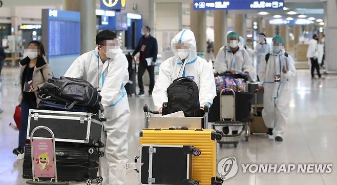 임시 격리시설로 향하는 해외 입국자들 (영종도=연합뉴스) 임헌정 기자 = 영국발 신종 코로나바이러스 감염증(코로나19) 변이 바이러스 확산 등 4차 유행 우려가 커지는 가운데 지난 2월 5일 영종도 인천국제공항에서 방역복을 입은 해외입국자들이 임시격리시설로 향하고 있다. [연합뉴스 자료사진]