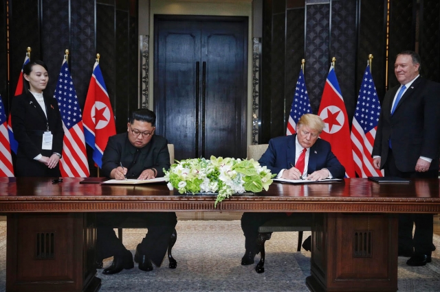 12일 김정은 북한 국무위원장과 도널드 트럼프 미국 대통령이 싱가포르 센토사섬 카펠라 호텔에서 북미정상회담 합의문 서명하고 있다. 뉴시스