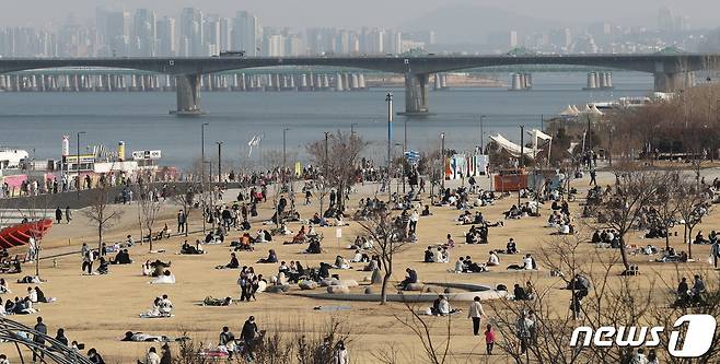 완연한 봄날씨를 보인 21일 오후 서울 여의도 한강공원을 찾은 시민들이 모처럼 따뜻한 봄기운을 만끽하고 있다. 2021.2.21/뉴스1 © News1 박지혜 기자