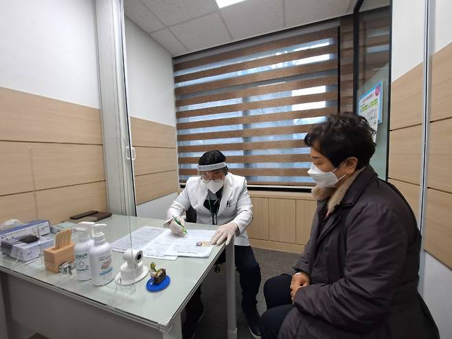 첫 접종자 이경순씨(61)가 코로나19 백신 접종전 문진을 받고 있는 모습/사진=홍순빈 기자