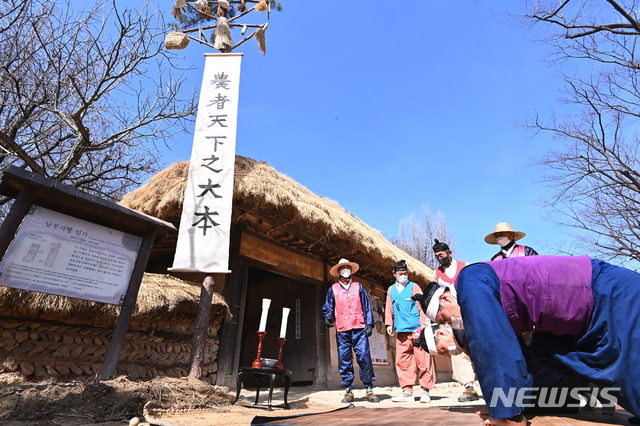 [용인=뉴시스] 김종택기자 = 정월 대보름인 26일 오후 경기도 용인 한국민속촌에서 관계자들이 벼·보리·조·기장 등 곡식을 장대에 매달아 세운 볏가릿대에서 풍요와 건강을 기원하고 있다. 2021.02.26. jtk@newsis.com