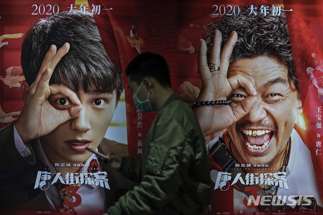 [베이징=AP/뉴시스]25일 중국 베이징의 폴리시네마에서 코로나19 확산 방지를 위해 마스크를 쓴 한 남성이 영화 '당인가탐안3' 포스터를 앞을 지나고 있다. 2021.02.26.