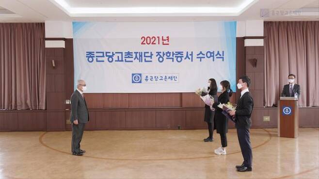 종근당고촌재단 김두현 이사장(왼쪽)이 26일 서울 충정로 종근당 본사에서 열린 ‘2021년도 장학증서 수여식’에서 장학생들에게 장학증서를 수여하고 있다. 종근당 제공