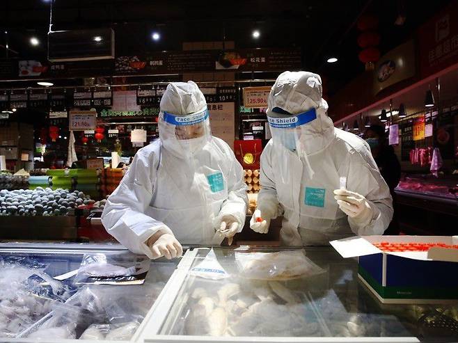 중국 방역 요원들이 냉동육과 포장재에 코로나 바이러스가  있는지 조사하고 있다./Sipa Asia