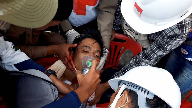 군부 쿠데타 발발 한 달을 앞둔 미얀마의 다웨이에서 28일(현지시간) 쿠데타 항의 시위 도중 총에 맞은 한 남성을 의료진이 치료하고 있다. 로이터 통신은 "미얀마 남부 다웨이 지역에서 경찰이 쏜 총에 맞아서 한 명이 숨지고, 여러 명이 부상했다"고 현지 매체를 인용해 전했다. [연합]