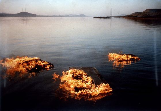 “Burning Canvases Floating on the River,” first performed in 1964 and recreated in this 1988 photo by Lee Seung-taek, the pioneer of Korean avant-garde art. The photo is included in the book ″Korean Art from 1953: Collision, Innovation, Interaction″ and is also on view now at the MMCA Seoul as part of Lee's retrospective .[MMCA]