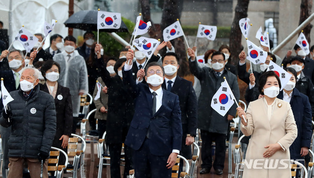 [서울=뉴시스]추상철 기자 = 문재인 대통령과 김정숙 여사가 1일 오전 서울 종로구 탑골공원에서 열린 제102주년 31절 기념식에 참석해 만세삼창을 한 후 태극기를 흔들고 있다. 독립운동가인 임우철(왼쪽) 애국지사. 2021.03.01. scchoo@newsis.com