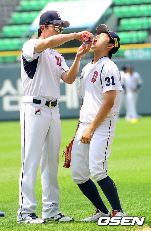 두산코치시절 김민호 코치가 한여름 훈련에 지친 정수빈에게 얼음물을 먹이고 있다.