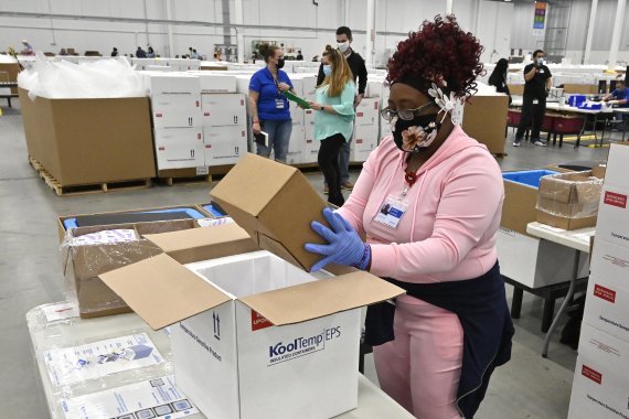 미국 켄터키주 셰퍼즈빌의 존슨앤드존슨(J&J) 코로나19 백신 공장에서 한 직원이 생산된 백신을 아이스박스에 담고 있다. 사진=AP뉴시스