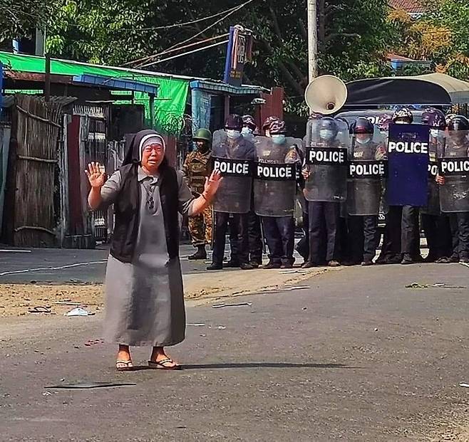 안 로사 누 타웅 수녀가 중무장한 경찰들 앞에 선 채 폭력 자제를 눈물로 호소하고 있다. 찰스 마웅 보 추기경 트위터 사진.