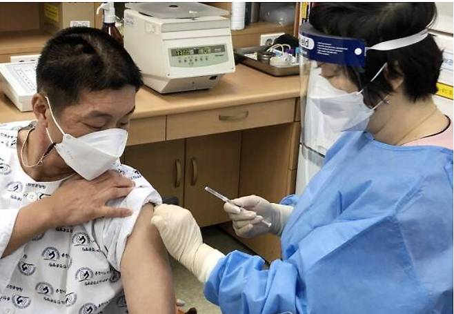 지난 26일 강원 춘천시 동면 노인요양병원에서 환자 김영선(54)씨가  코로나19 백신 접종을 하고 있다.  춘천시 제공