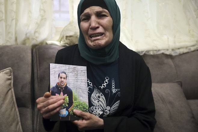 팔레스타인인이 지난해 5월 30일 이스라엘 경찰에게 사살된 아들의 사진을 동예루살렘의 자택에서 들고 오열하고 있다. 예루살렘｜AP연합뉴스