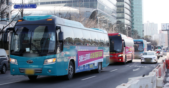 Chartered bus drivers from nationwide head toward Yeouido in western Seoul on Feb. 18 to call on the government to include them in its Covid-19 stimulus package. [NEWS1]