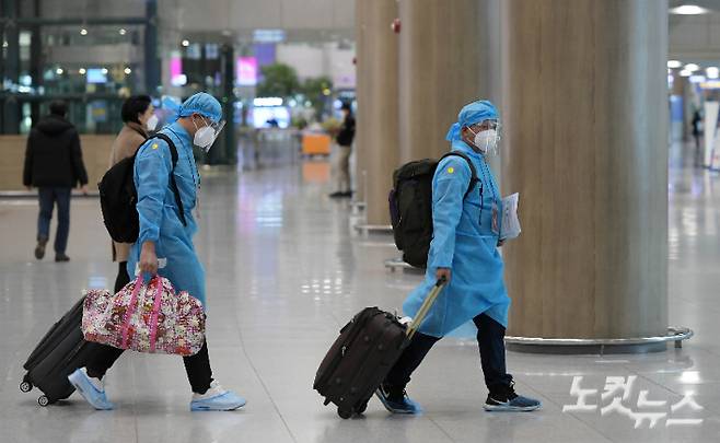 영국발 신종 코로나바이러스 감염증(코로나19) 변이 바이러스로 우려가 커지는 가운데 5일 인천국제공항에서 방역복을 입은 외국인들이 입국장을 나서고 있다 이한형 기자