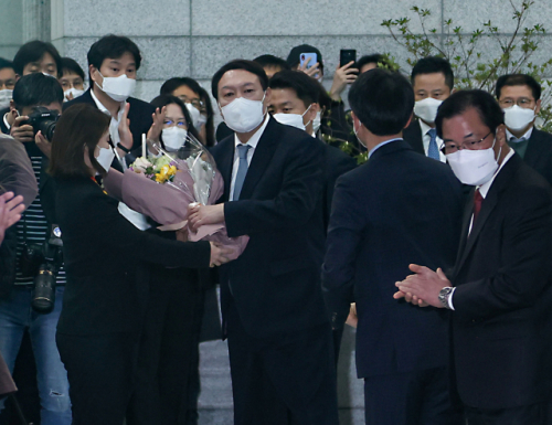 윤 총장이 직원에게 꽃다발을 받고 있다. /연합뉴스