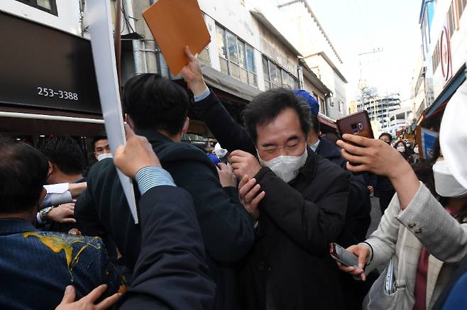 더불어민주당 이낙연 대표가 5일 오후 강원 춘천시 중앙시장을 방문하던 도중 레고랜드 반대 단체 관계자가 달걀을 던져 몸을 피하고 있다. 연합뉴스민주당 이낙연 대표가 5일 오후 강원 춘천시 중앙시장을 방문하던 도중 레고랜드 반대 단체 관계자가 달걀을 던져 몸을 피하고 있다. 연합뉴스