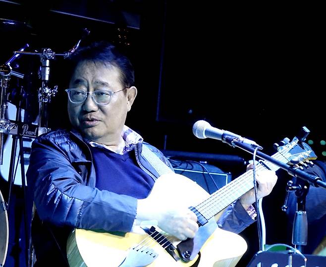 포크의 거장 이정선이 한 공연장에서 기타를 연주하며 노래하고 있다. /이정선 페이스북