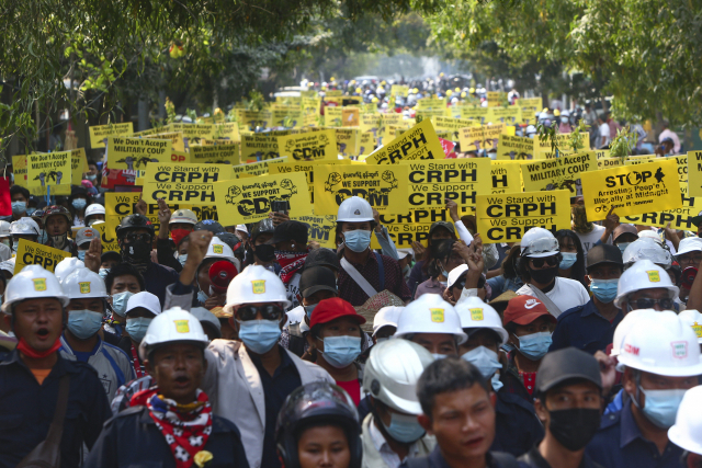 미얀마의 지방도시 만달레이에서 6일 반군부 시위대가 헬멧과 마스크를 착용하고 거리를 행진하고 있다./AP연합뉴스