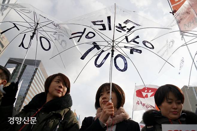 여성단체회원들이 ‘유리천장 아웃’이 적힌 우산을 들고 시위를 하고 있다./박민규 선임기자