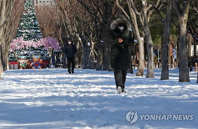 눈 쌓인 공원 지난 1월 7일 대전시 서구 보라매공원을 지나는 시민들이 눈이 쌓인 길을 걸으며 발걸음을 재촉하는 모습. [연합뉴스 자료사진]