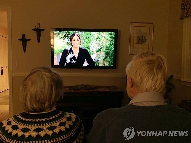 7일(현지시간) 미국에서 방영된 영국 해리 왕자 부부 인터뷰를 지켜보는 사람들. [EPA=연합뉴스]