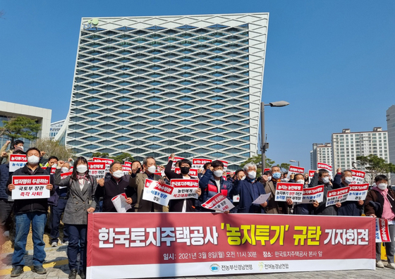 Members of the National Farmers' League protest purchases by LH employees of agricultural land outside of the company's headquarters in Jinju, South Gyeongsang on Monday. [YONHAP]