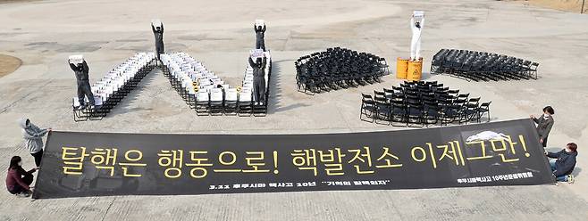 후쿠시마 핵사고 10주년 준비위원회 관계자들이 ‘NO’ 모양으로 배치된 의자 311개를 배경으로 기억의 탈핵의자 거리행위극을 하고 있다. 이정용 선임기자