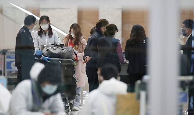 인천국제공항 제2터미널에서 입국자들이 공항 관계자들의 안내를 받고 있다. 연합뉴스