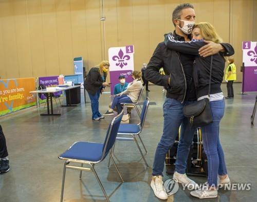 지난 4일(현지시간) 미국 뉴올리언스의 한 컨벤션센터에서 존슨앤드존슨의 코로나19 백신을 맞은 한 부부가 포옹하고 있다. 사진은 기사 내용과 직접 연관이 없음. [AP=연합뉴스 자료사진]