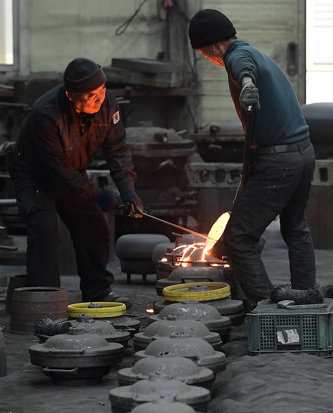 안성주물공장 기술자들이 1850℃ 이상의 쇳물을 가마솥 모양의 거푸집(틀)에 붓고 있다.