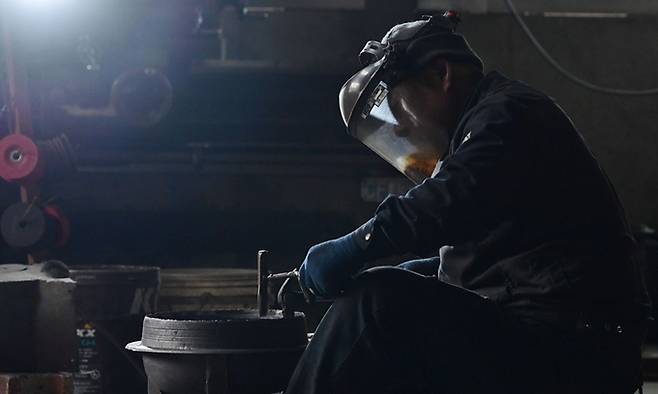 안성주물공장에서 직원이 거푸집에서 나온 가마솥을 다듬고 있다.