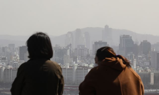 시민들이 지난 16일 서울 성동구 응봉산에서 서울 시내 아파트 단지를 바라보고 있다. 연합뉴스