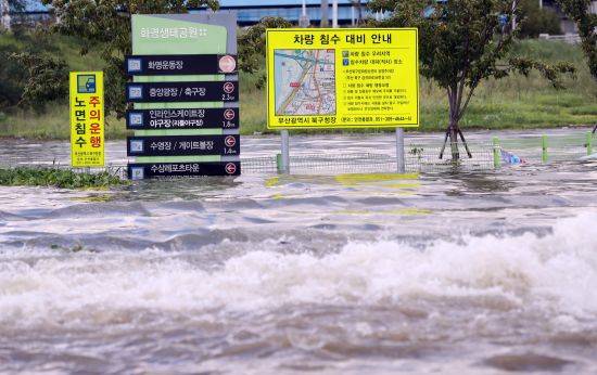 지난 2019년 10월 부산 화명생태공원 진입로가 침수돼 도로 표지판 상단만 보이고 있다. 연합.