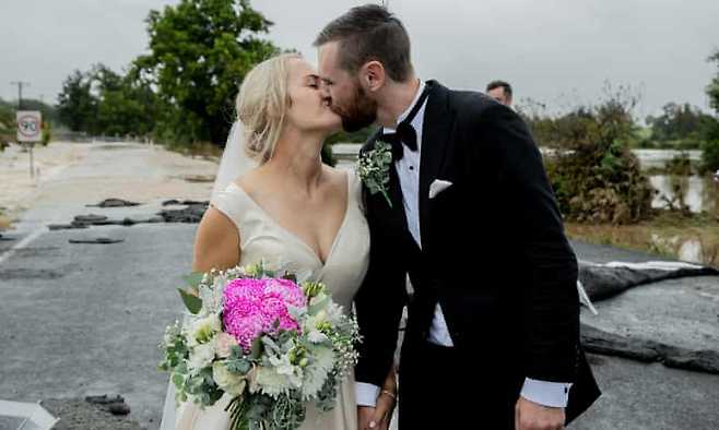 도로 곳곳이 파손될 정도의 심각한 홍수 피해 속에서도 굴하지 않고 결혼식을 치른 호주 커플의 결혼식 당시 모습