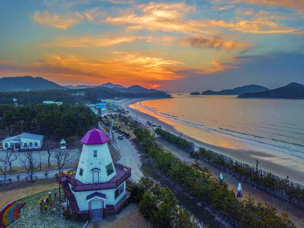 해가 질 무렵 전남 신안군 임자면 대광해수욕장 바로 옆 튤립공원 위에서 드론으로 내려다본 모습. 이국적인 풍차 너머 길게 이어진 해변은 비금도 명사십리, 암태도 추포, 도초 시목해수욕장과 더불어 신안의 4대 해수욕장으로 꼽힌다.