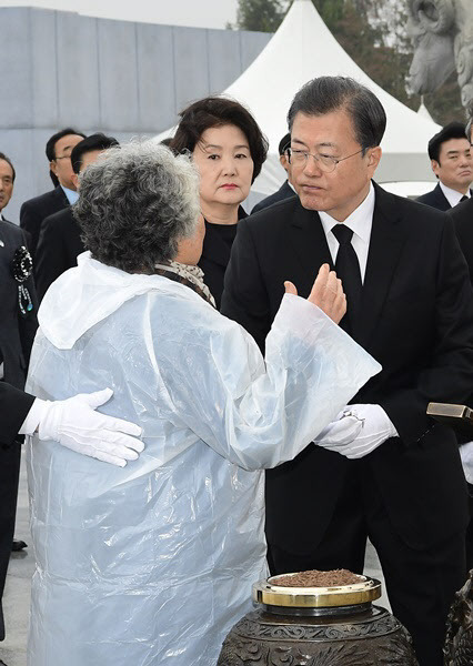 지난해 3월 27일 오전 국립대전현충원에서 열린 ‘서해수호의 날’ 기념식에서 분향하려는 문재인 대통령에게 다가간 윤청자(77)씨를 김정숙 여사가 바라보고 있다 (사진=연합뉴스)