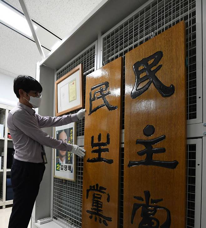 기록관리과 직원이 행정박물서고에 보관 중인 옛 민주당 현판을 살펴보고 있다.