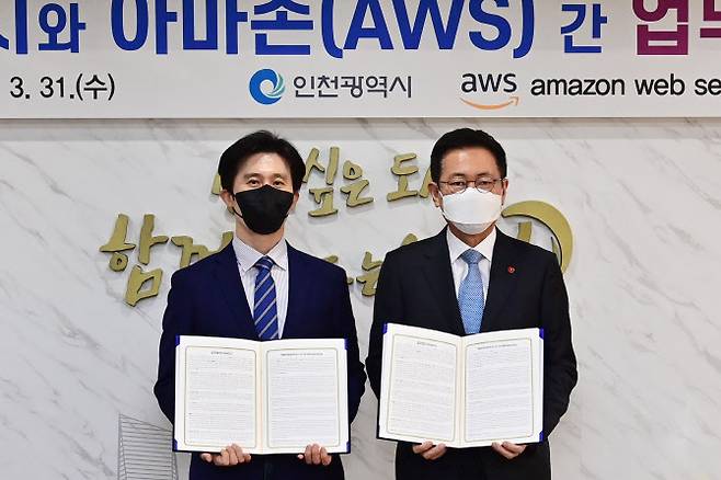 박남춘(오른쪽) 인천시장이 31일 시청 접견실에서 윤정원 아마존웹서비스코리아 공공부문 대표와 업무협약을 한 뒤 기념 촬영하고 있다. (사진 = 인천시 제공)