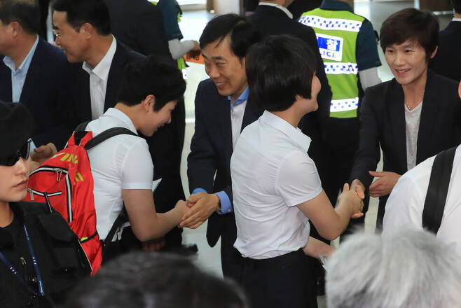 2018년 7월23일 오후 인천국제공항에서 유남규(오른쪽 셋째)·현정화(맨 오른쪽) 감독이 출국을 앞둔 북한 선수들과 악수하고 있다. 연합뉴스